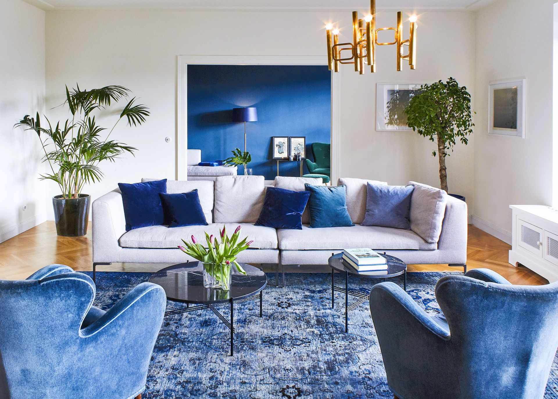 Ein Wohnzimmer mit einer weißen Couch und blauen Stühlen