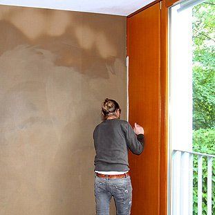 Eine Frau steht in einem Raum neben einem Fenster