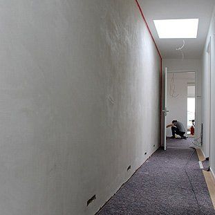 Ein Mann kniet in einem langen Flur.