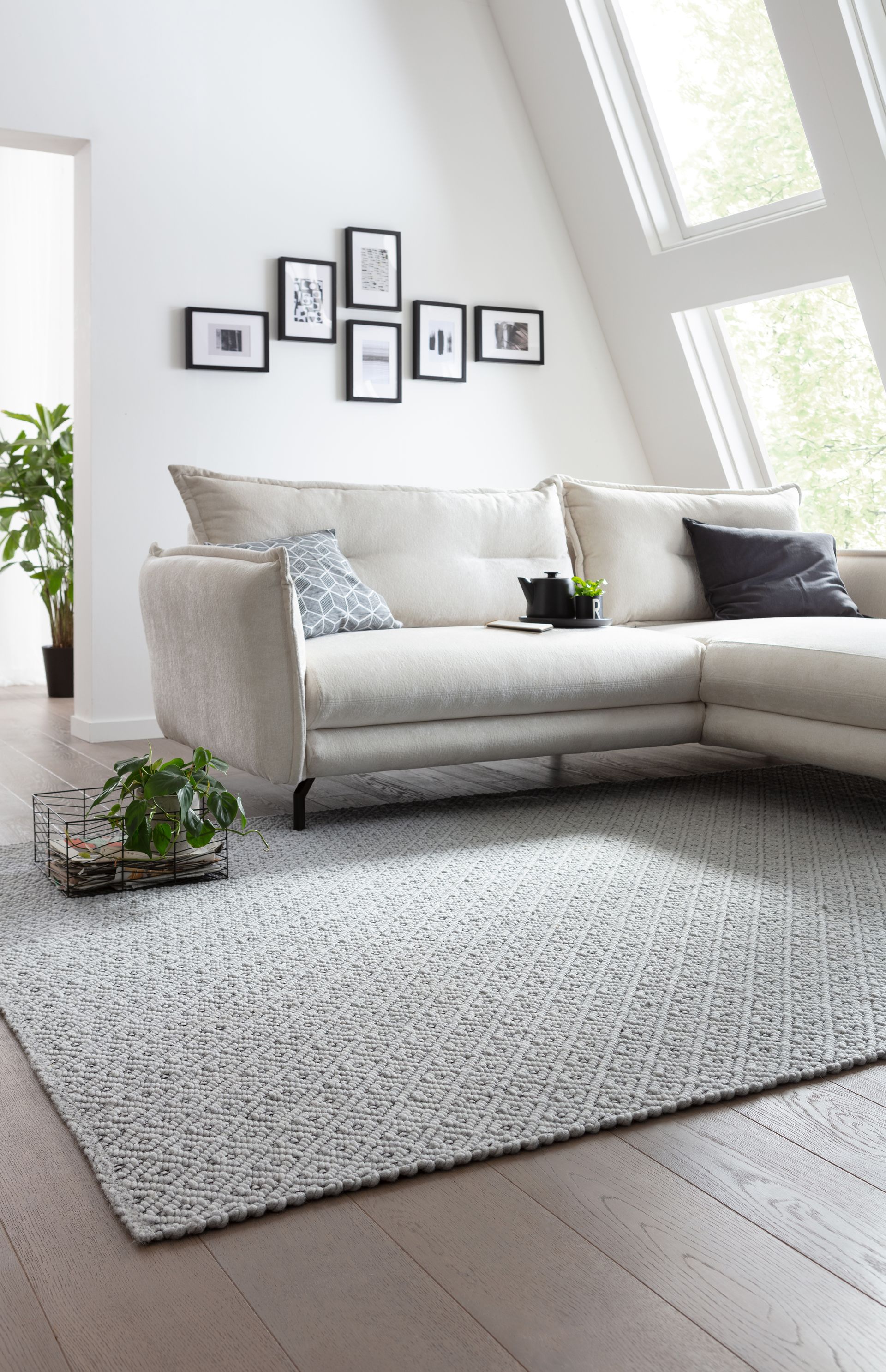 Ein Wohnzimmer mit Couch, Teppich und Bildern an der Wand.