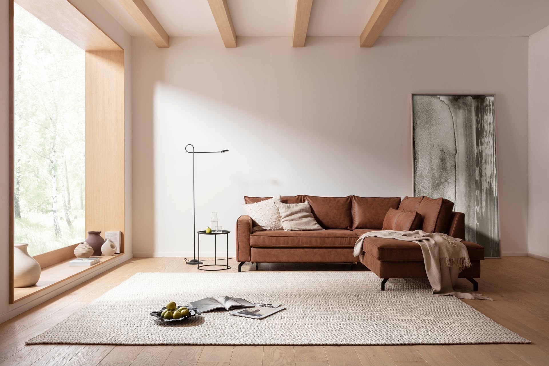 Ein Wohnzimmer mit einer braunen Sofagarnitur und einem weißen Teppich.