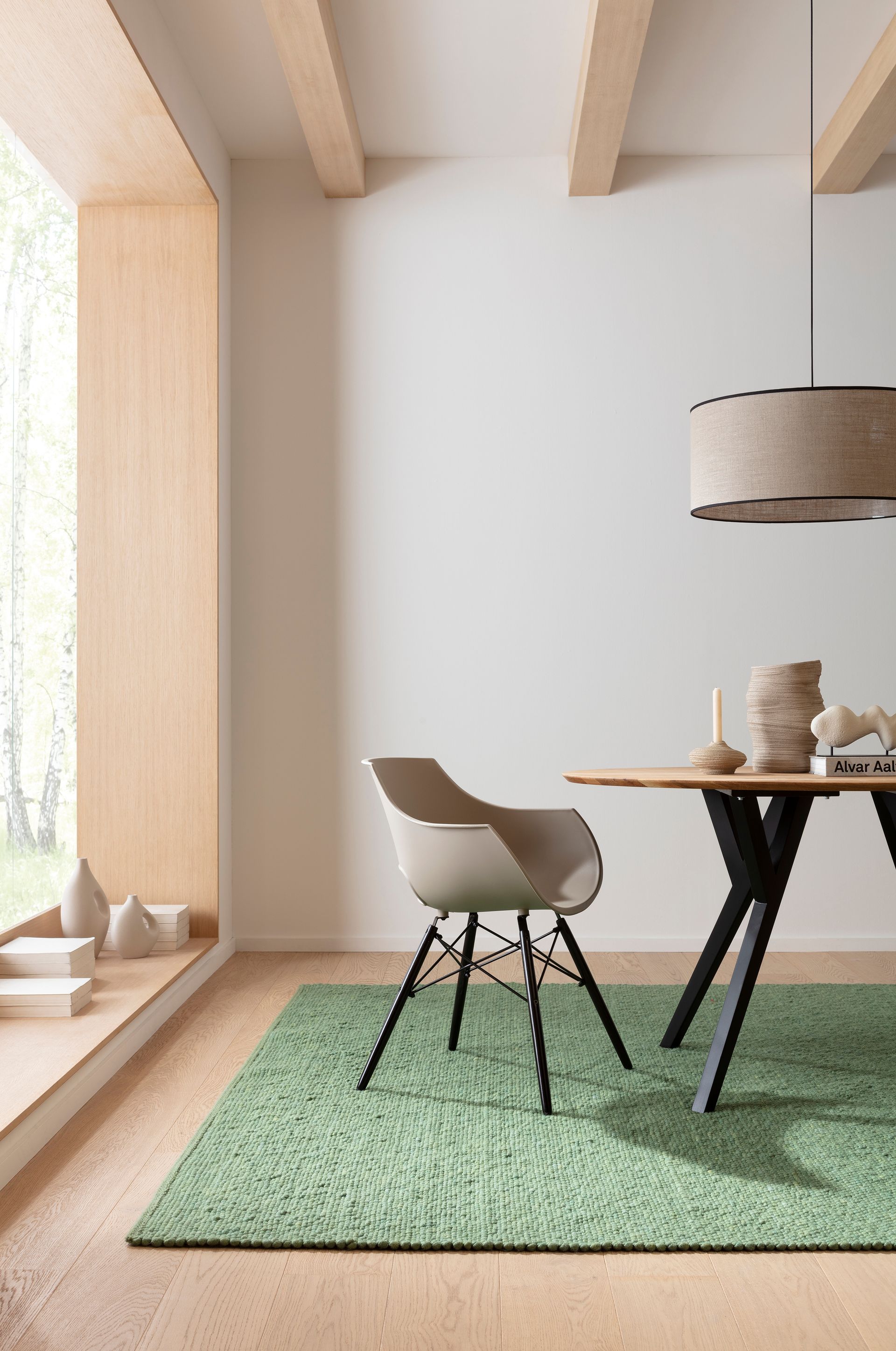 Ein Esszimmer mit Tisch und Stühlen und einem grünen Teppich.