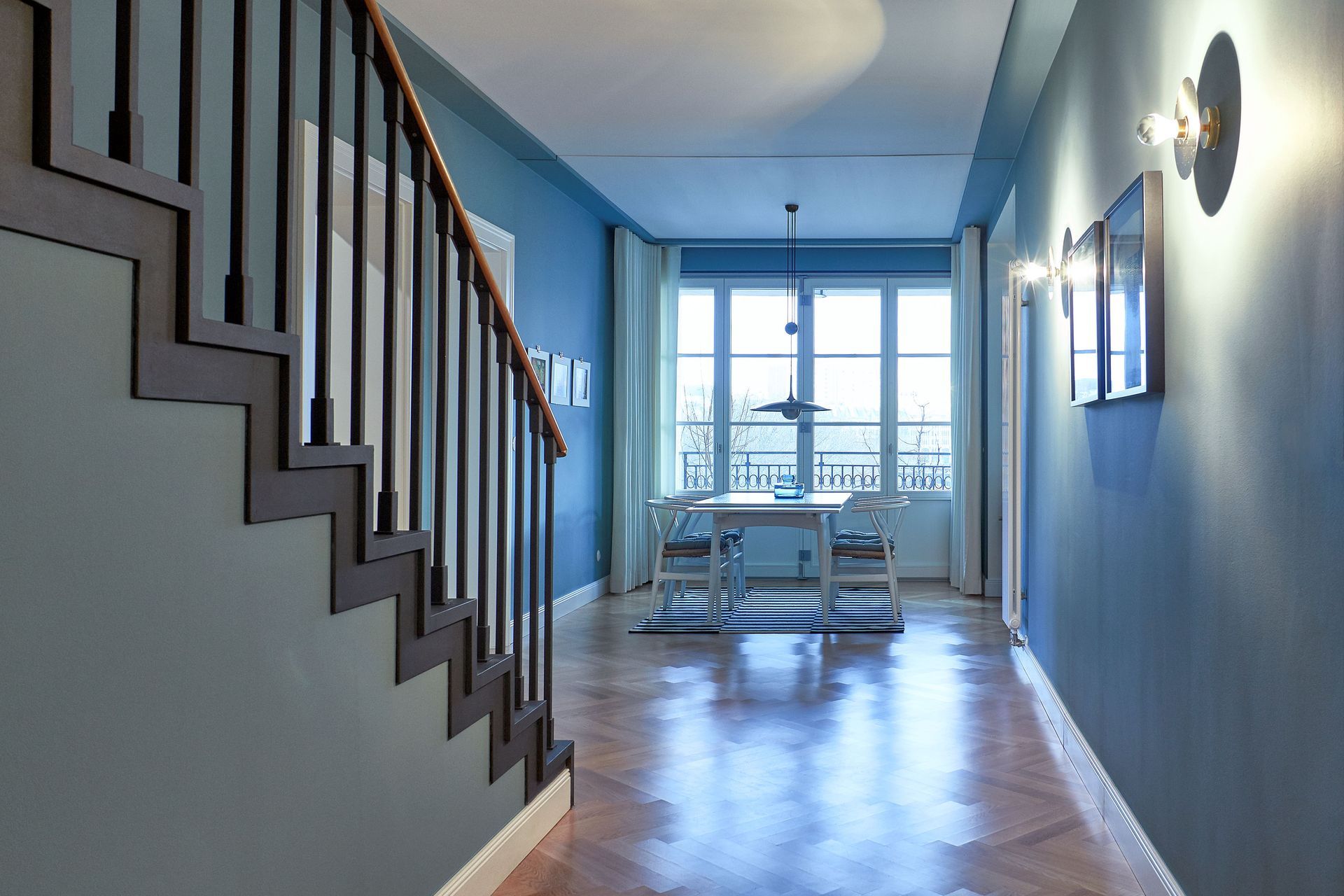 Ein Flur mit Treppe, die zu einem Esszimmer führt