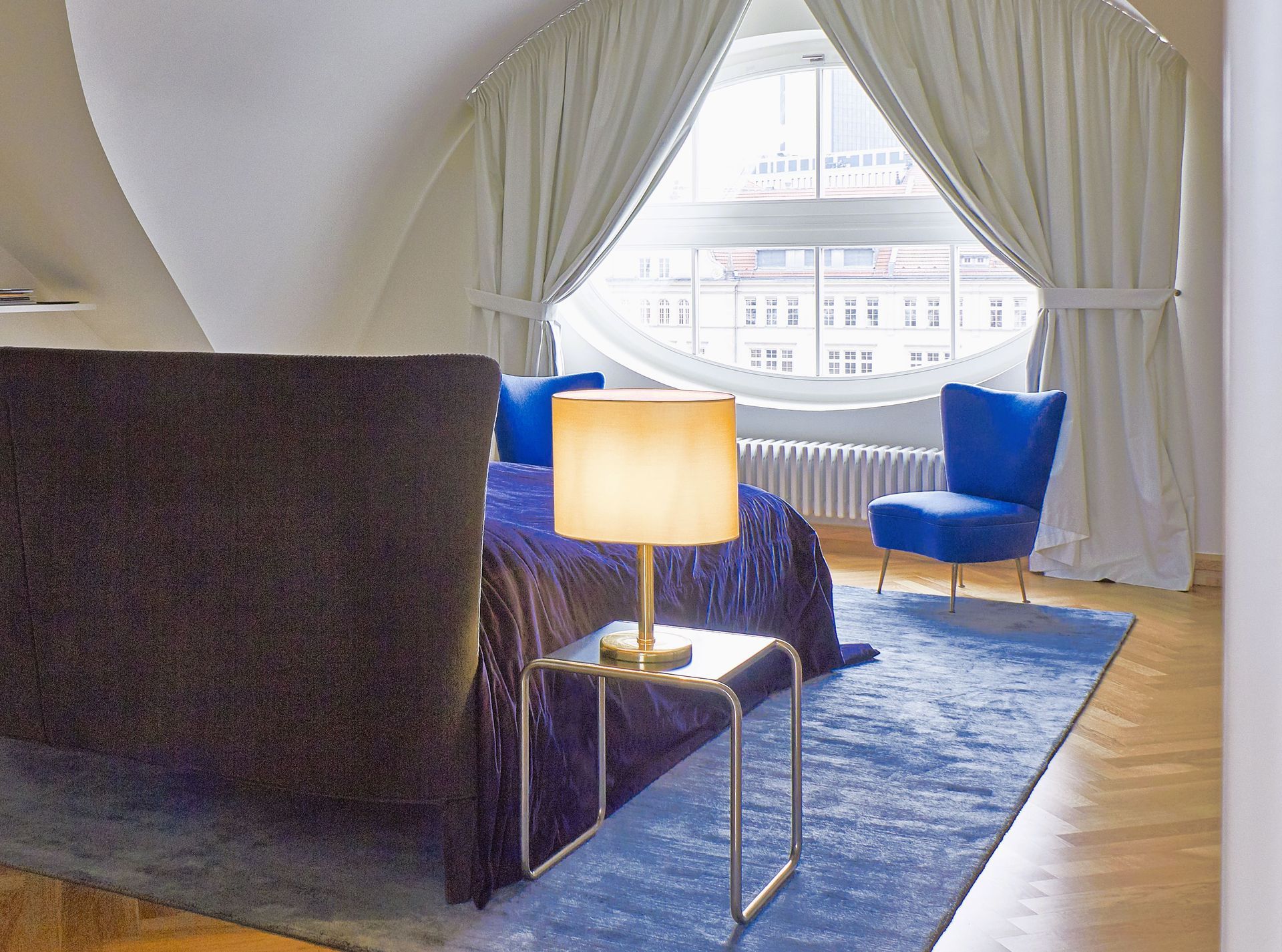Ein Schlafzimmer mit einem Bett und zwei Stühlen und einer Lampe
