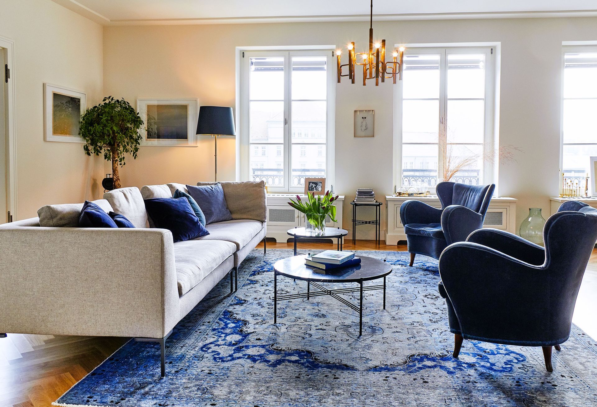 Ein Wohnzimmer mit einer Couch und Stühlen und einem blauen Teppich