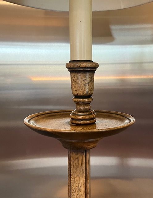 Close-up of a rustic brass-and-wood lamp base with a cream lampshade against a blurred background