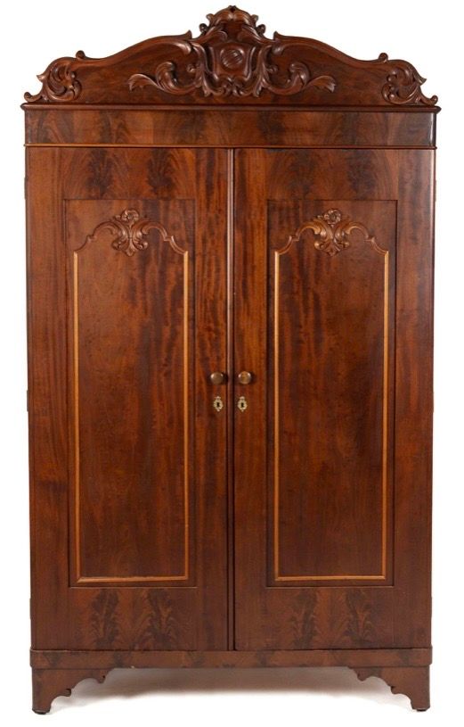 Antique dark wood armoire with carved top and double doors Antique dark wood armoire with carved top and double doors