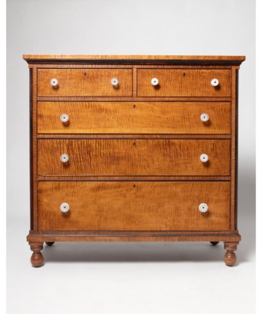 Wooden dresser with four drawers, small round knobs, and tapered legs on a white background Wooden dresser with four drawers, small round knobs, and tapered legs on a white background