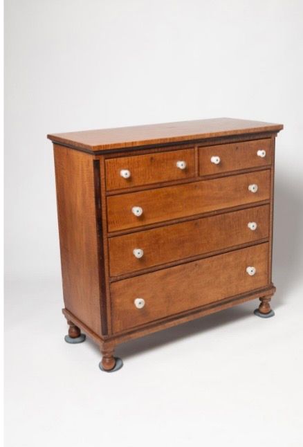 Wooden four-drawer dresser with round knobs, shown against a white background.
