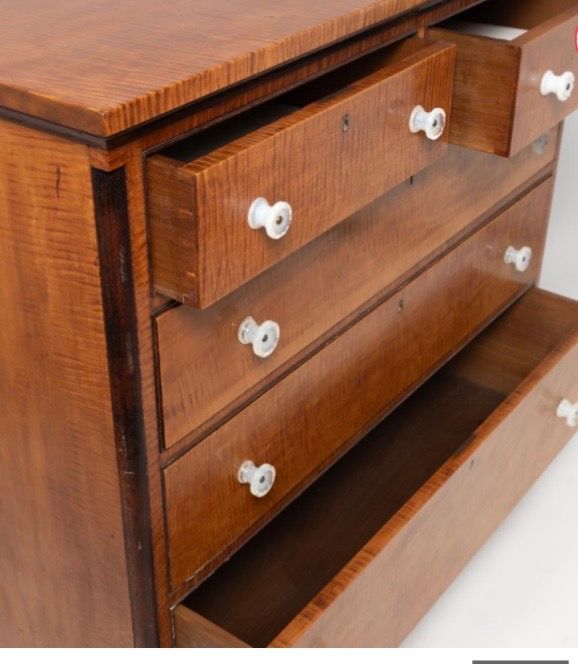 Open wooden dresser with several drawers pulled out, showing white knobs.
