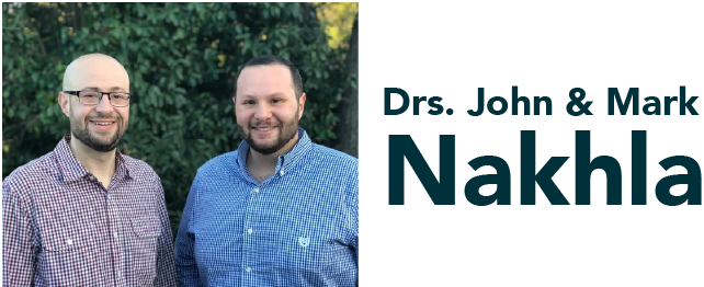 Two men are standing next to each other in front of a sign that says drs. john & mark nakhla
