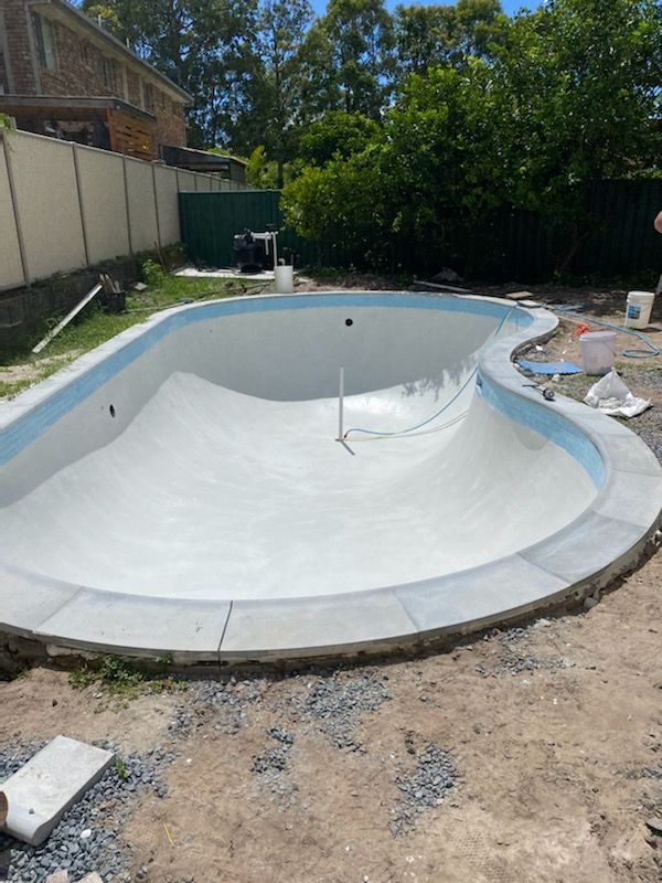 Empty, freshly plastered swimming pool, under construction in a backyard. — Worrall Tiling in South Kempsey, NSW