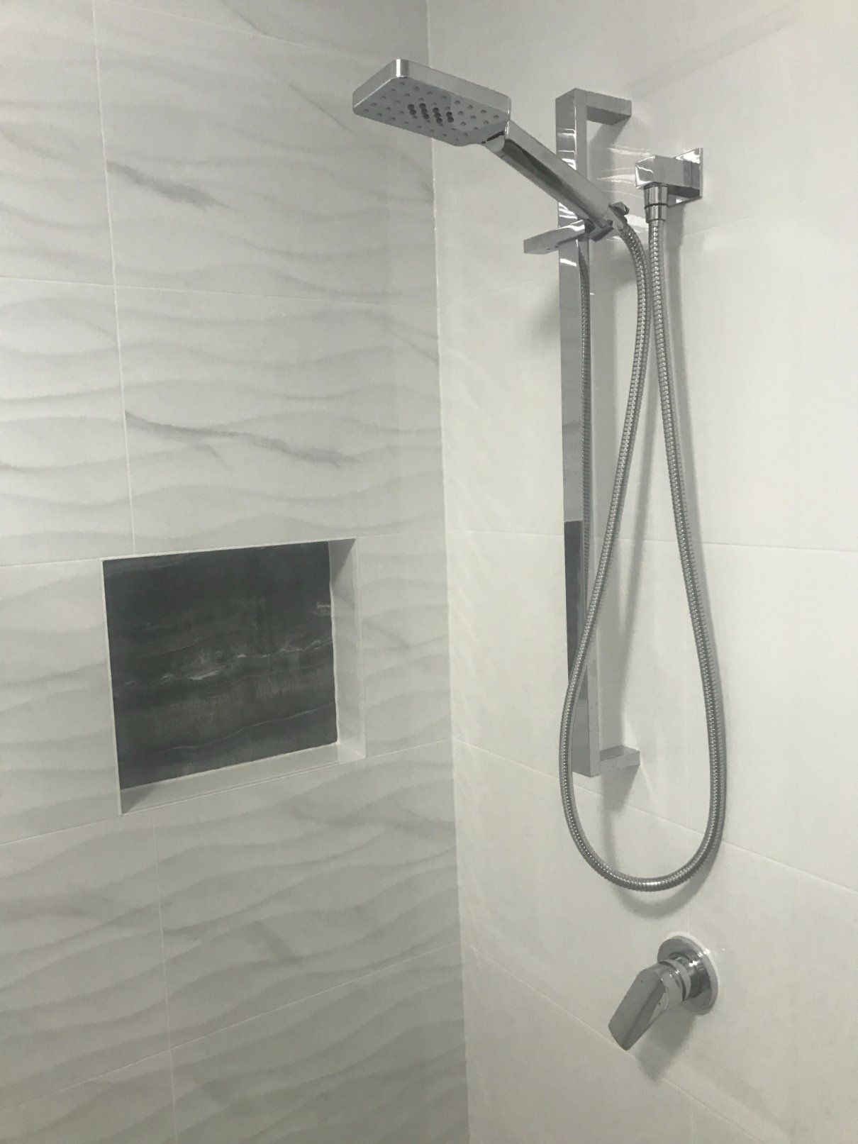 Shower With Silver Fixtures and White Wavy Tile — Worrall Tiling in Port Macquarie, NSW
