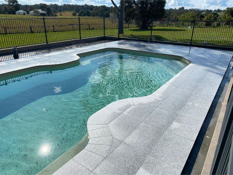 Swimming Pool With a Light-coloured Tiled Deck — Worrall Tiling in South Kempsey, NSW