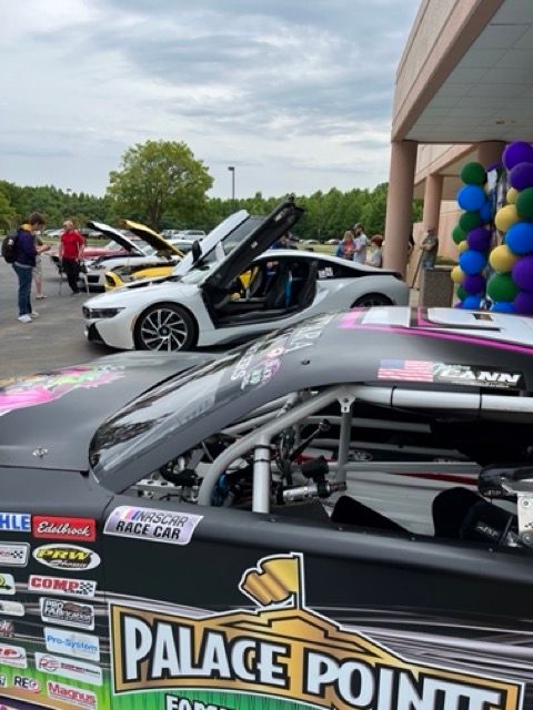 A race car is parked in front of a building that says palace point
