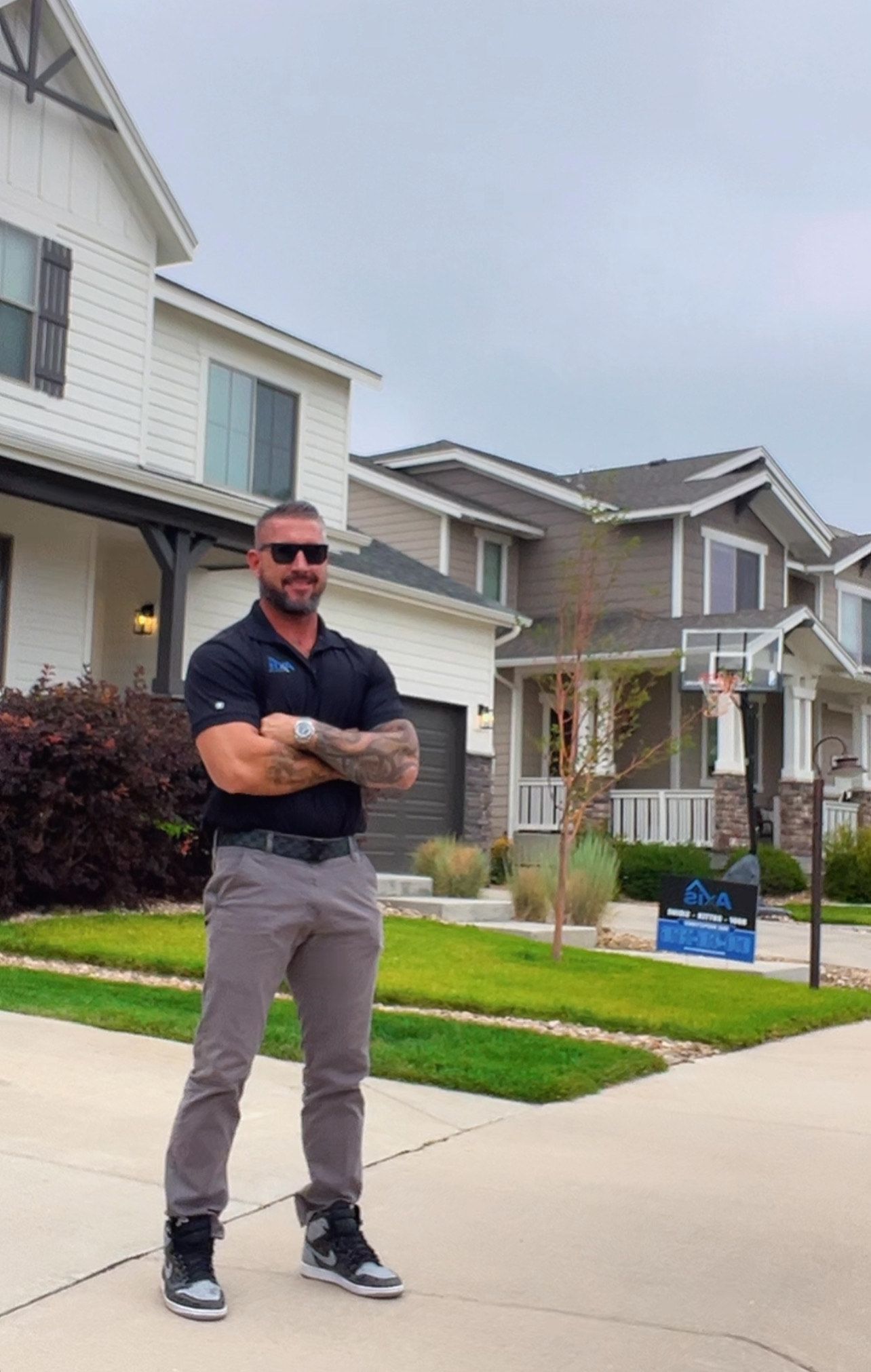 A man wearing a hat and sunglasses is sitting in the back seat of a car.
