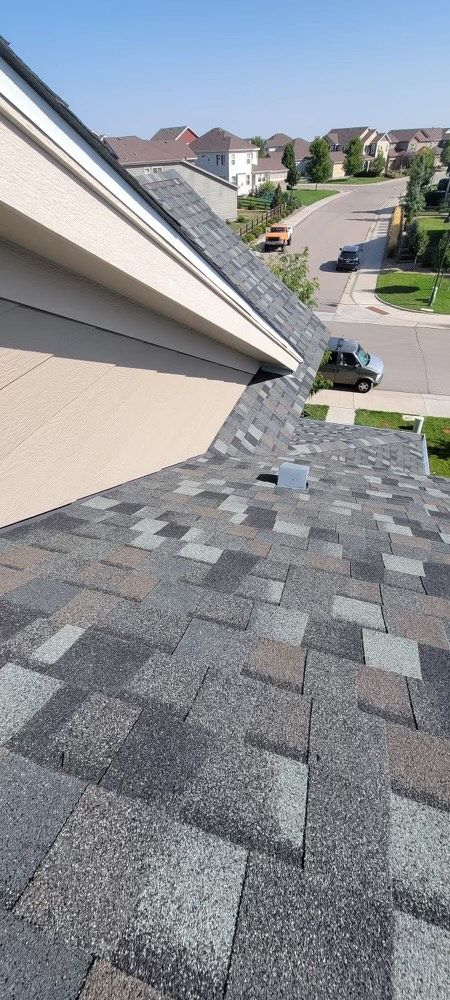 A man on a ladder is working on a roof.