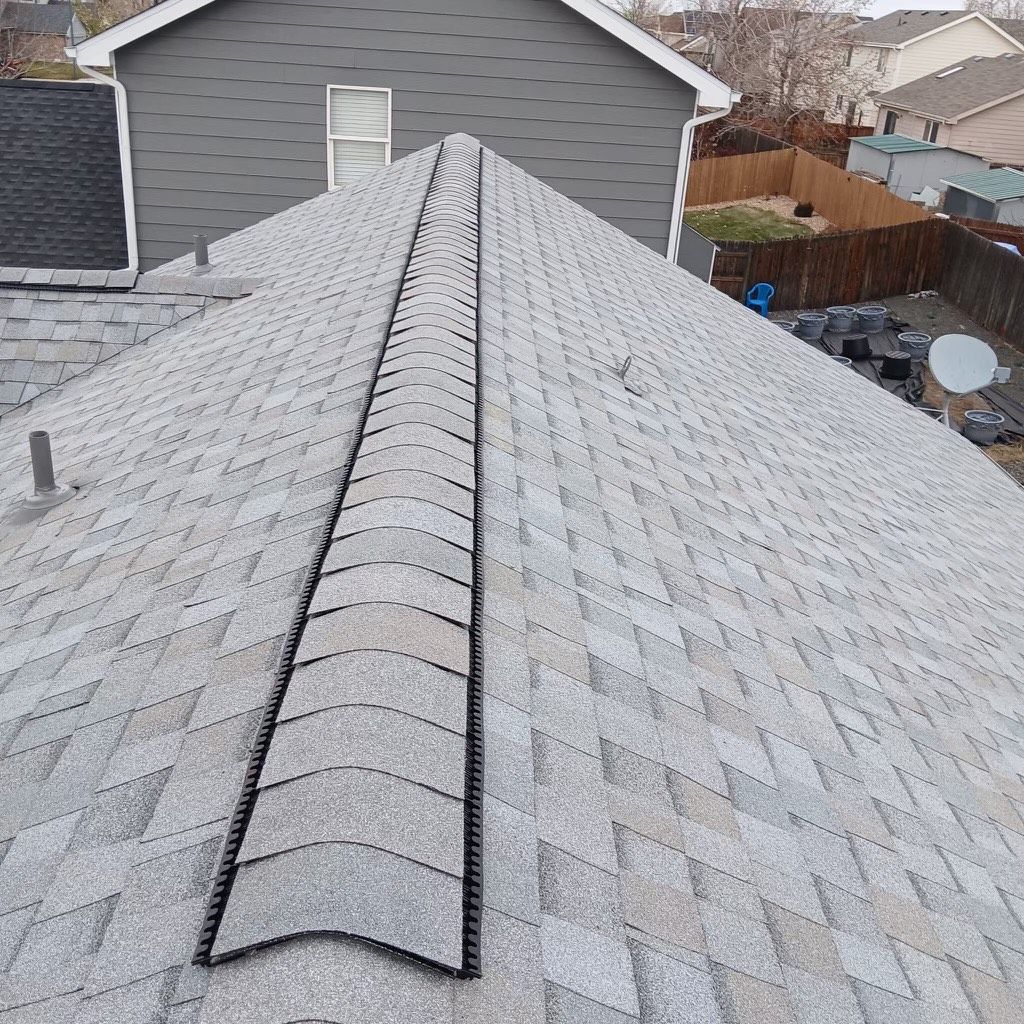 A large house with a large deck and a large lawn in front of it.