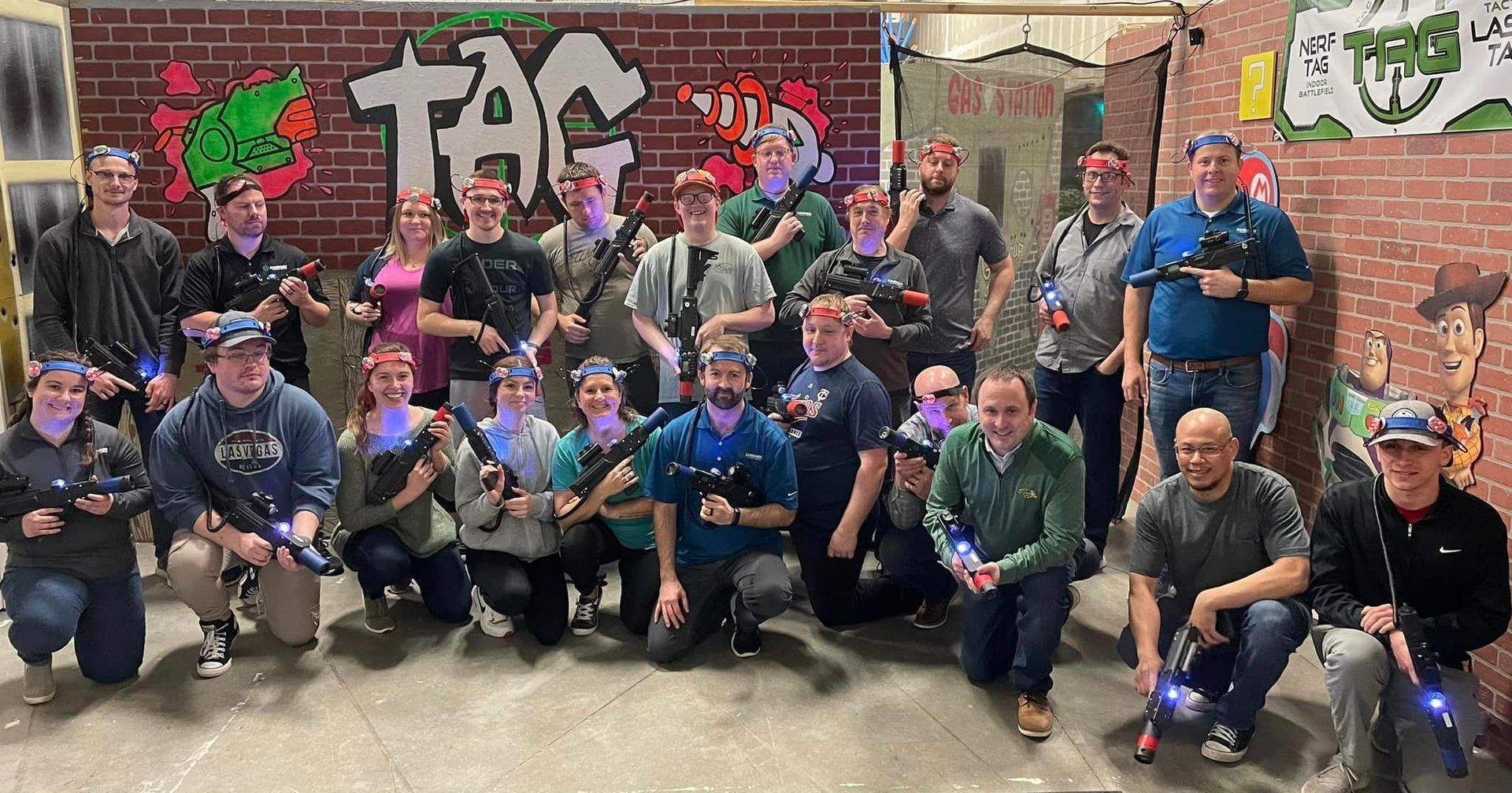 team of employees doing a team building activity of playing laser tag