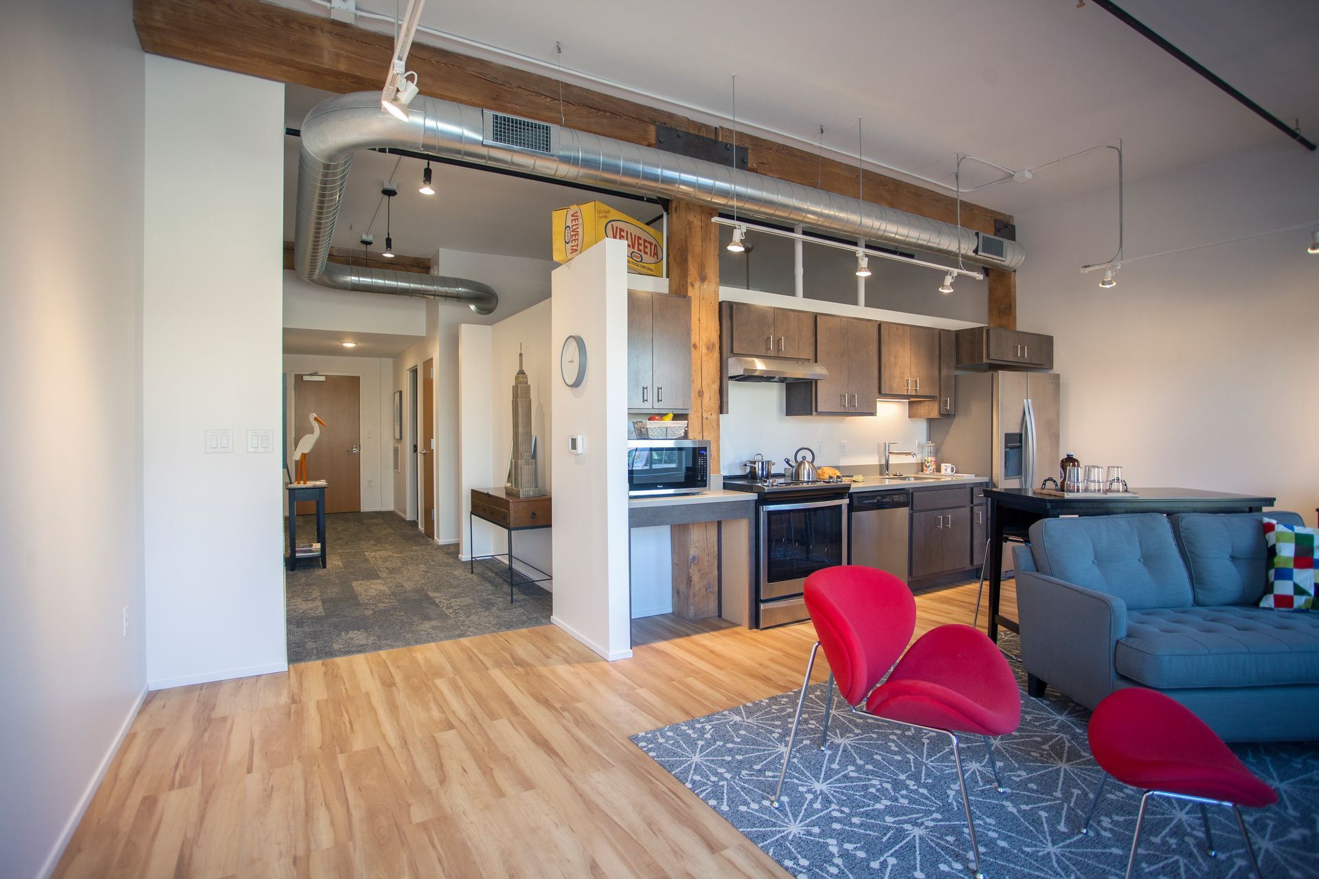 a living room with a couch and chairs and a kitchen