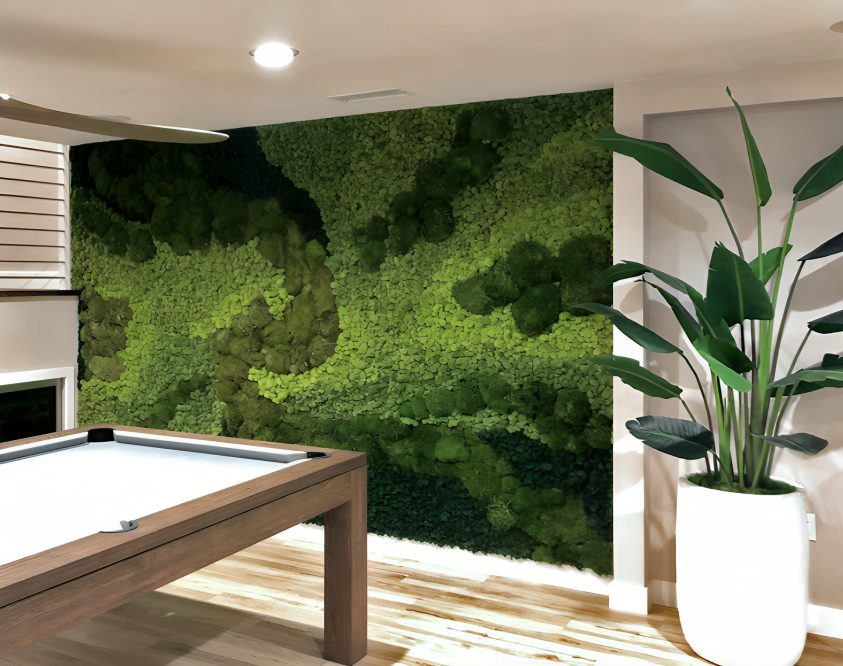 A pool table in a room with a green wall and a potted plant.