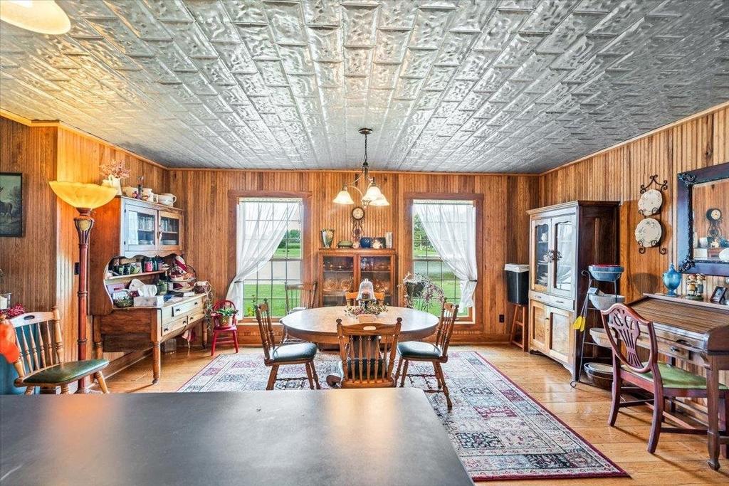 A dining room with a table and chairs and a ping pong table.
