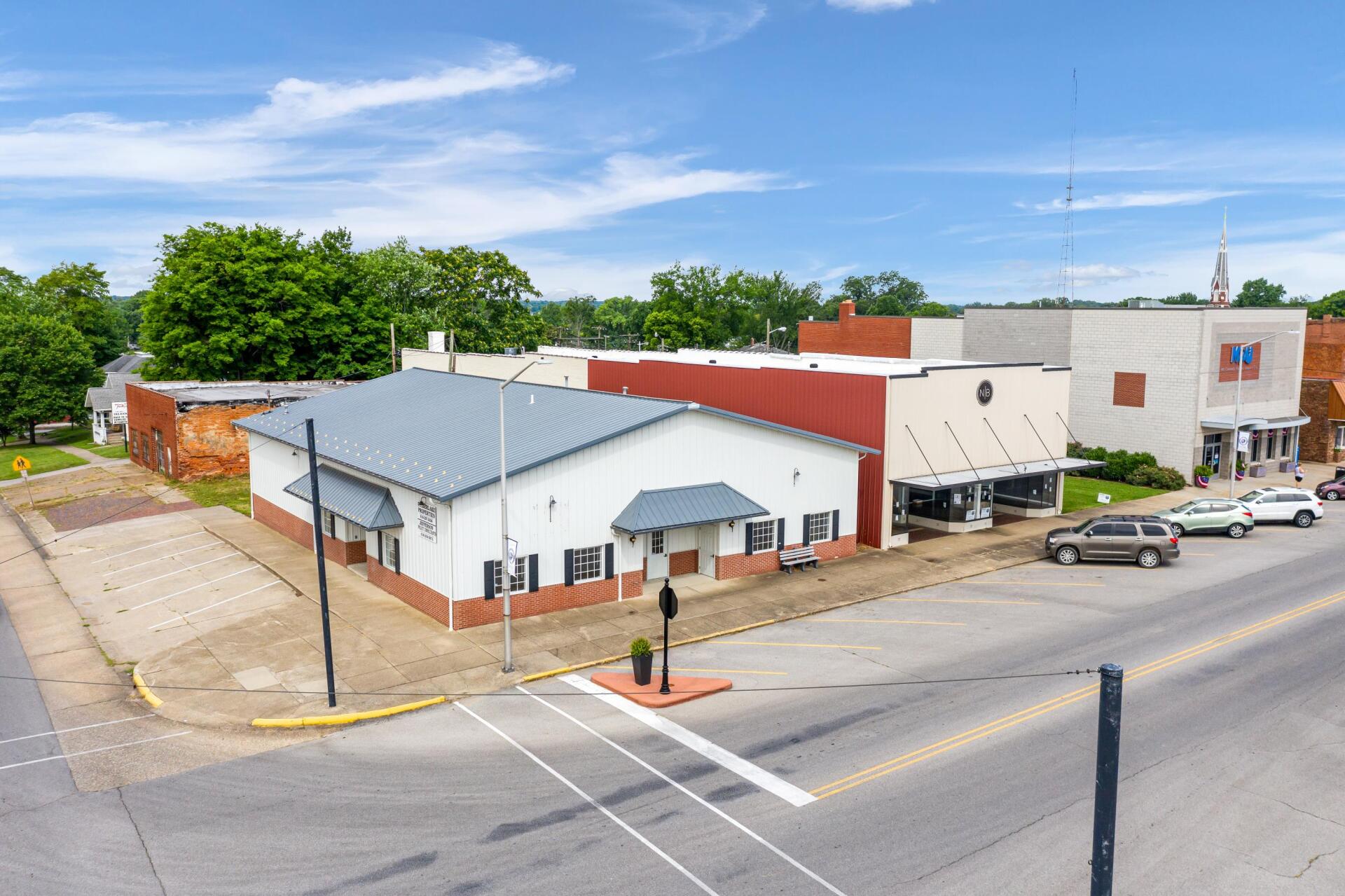 An aerial view of a small town with a lot of buildings and cars parked on the side of the road.