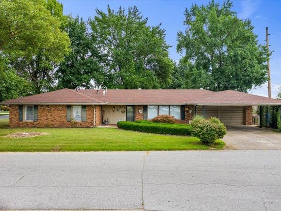 A large brick house with a brown roof is for sale.