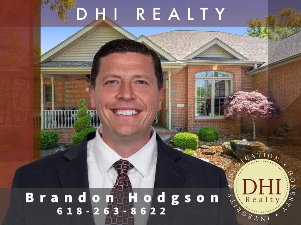 Brandon hodgson is smiling in front of a brick house