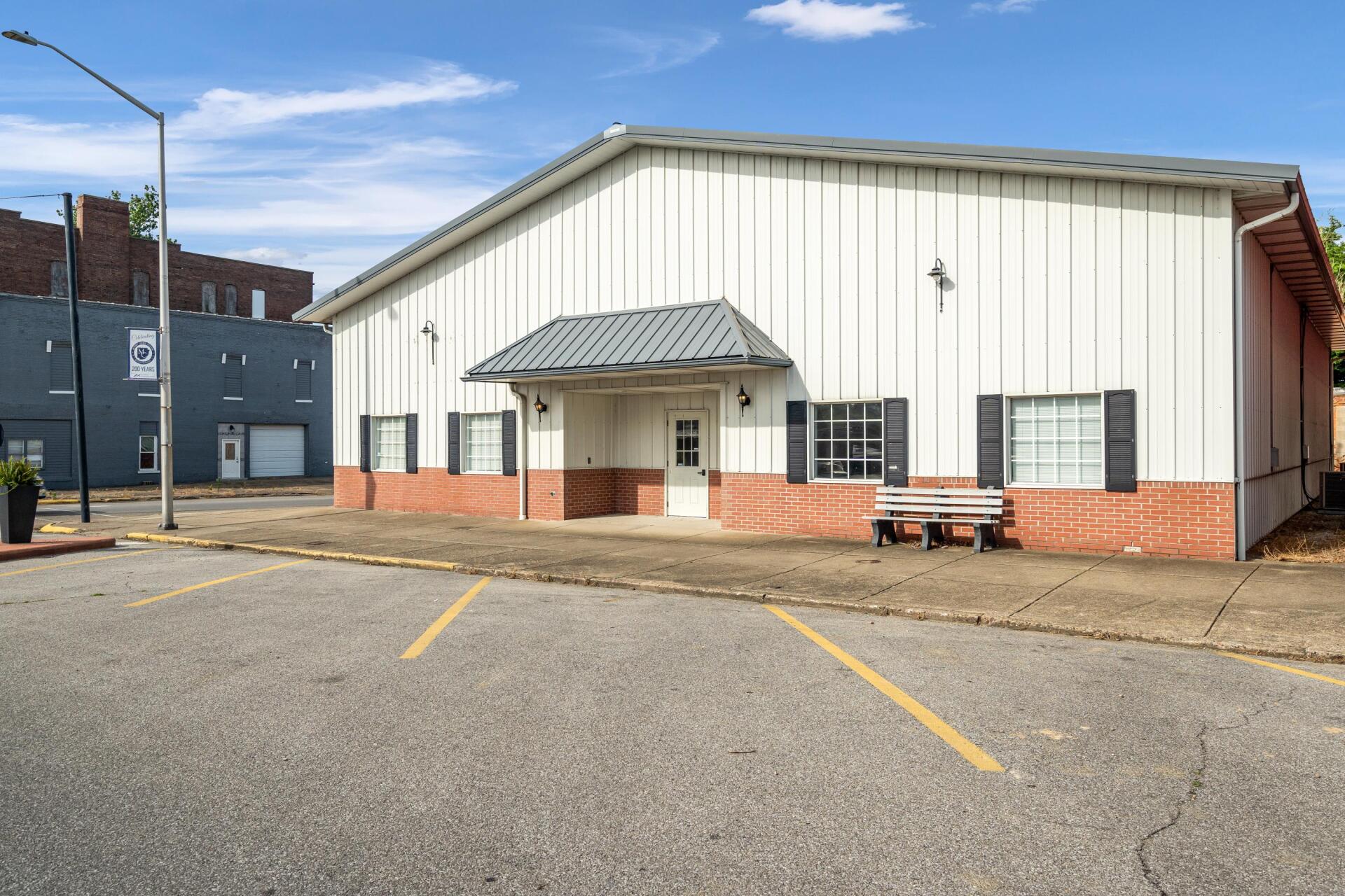 A large white building with a bench in front of it.