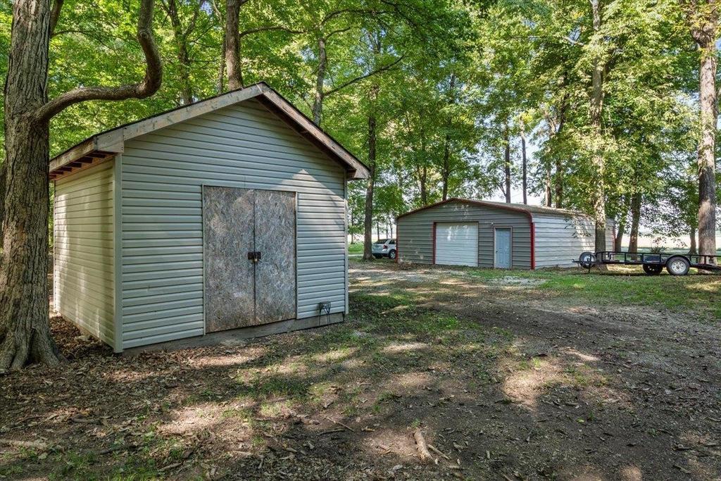 A couple of sheds sitting next to each other in a yard surrounded by trees.