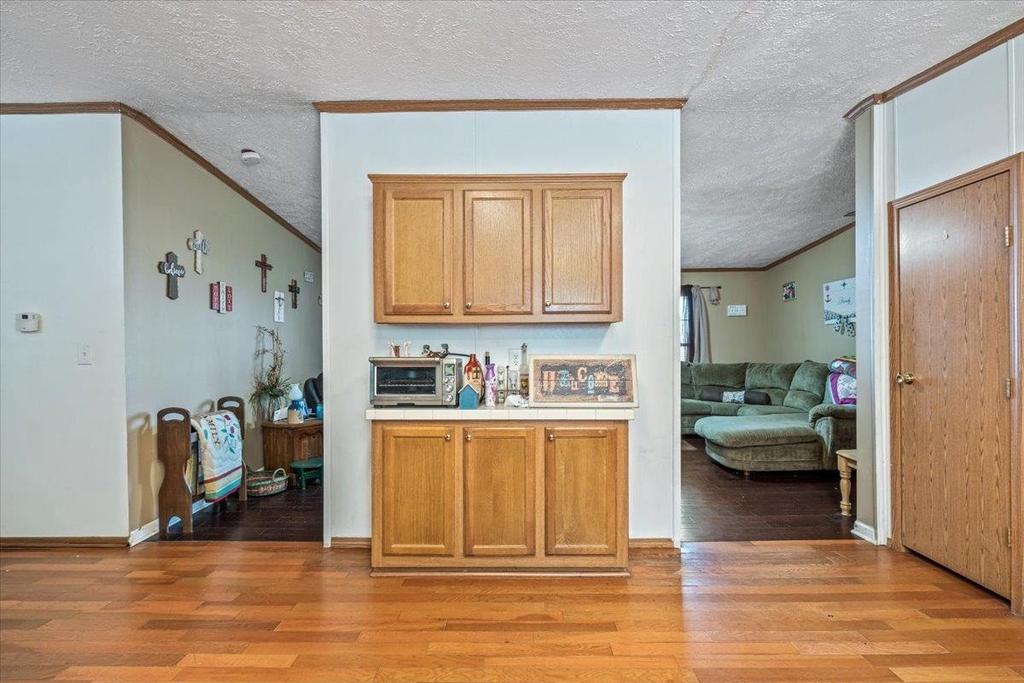A living room with hardwood floors and wooden cabinets