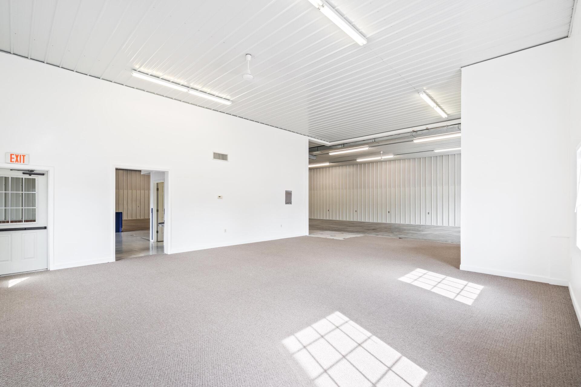 A large empty room with white walls and a carpeted floor.