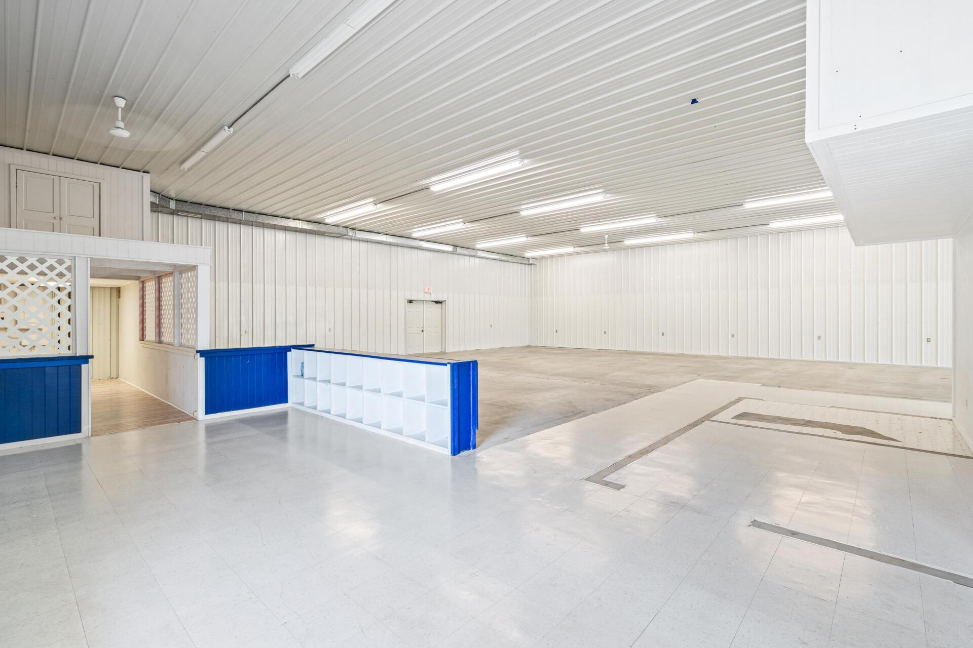 A large empty warehouse with white walls and blue counters.