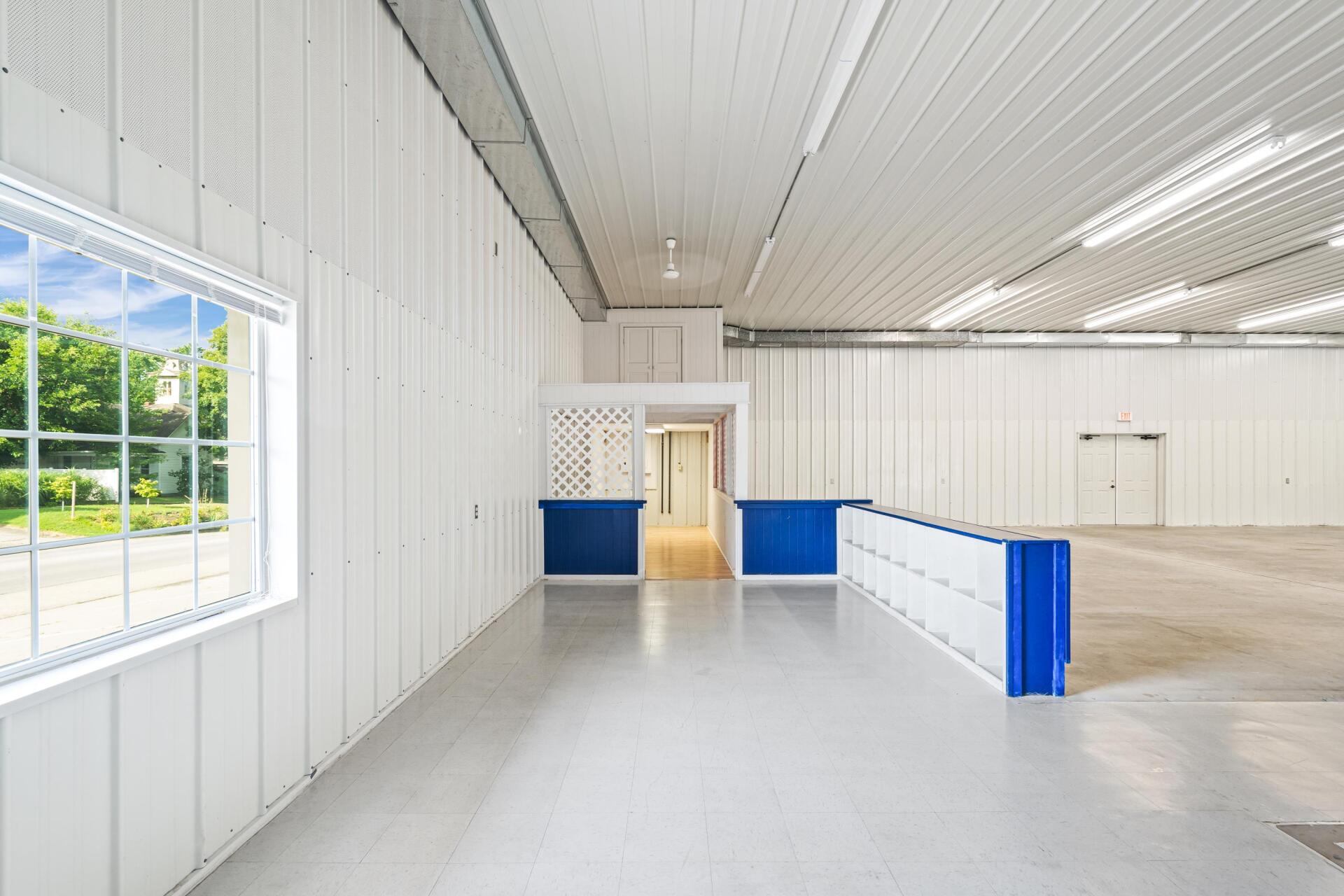 A large empty room with white walls and blue counters.