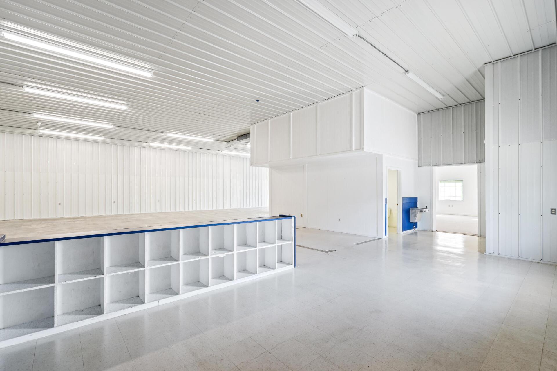 A large empty warehouse with white walls and shelves.