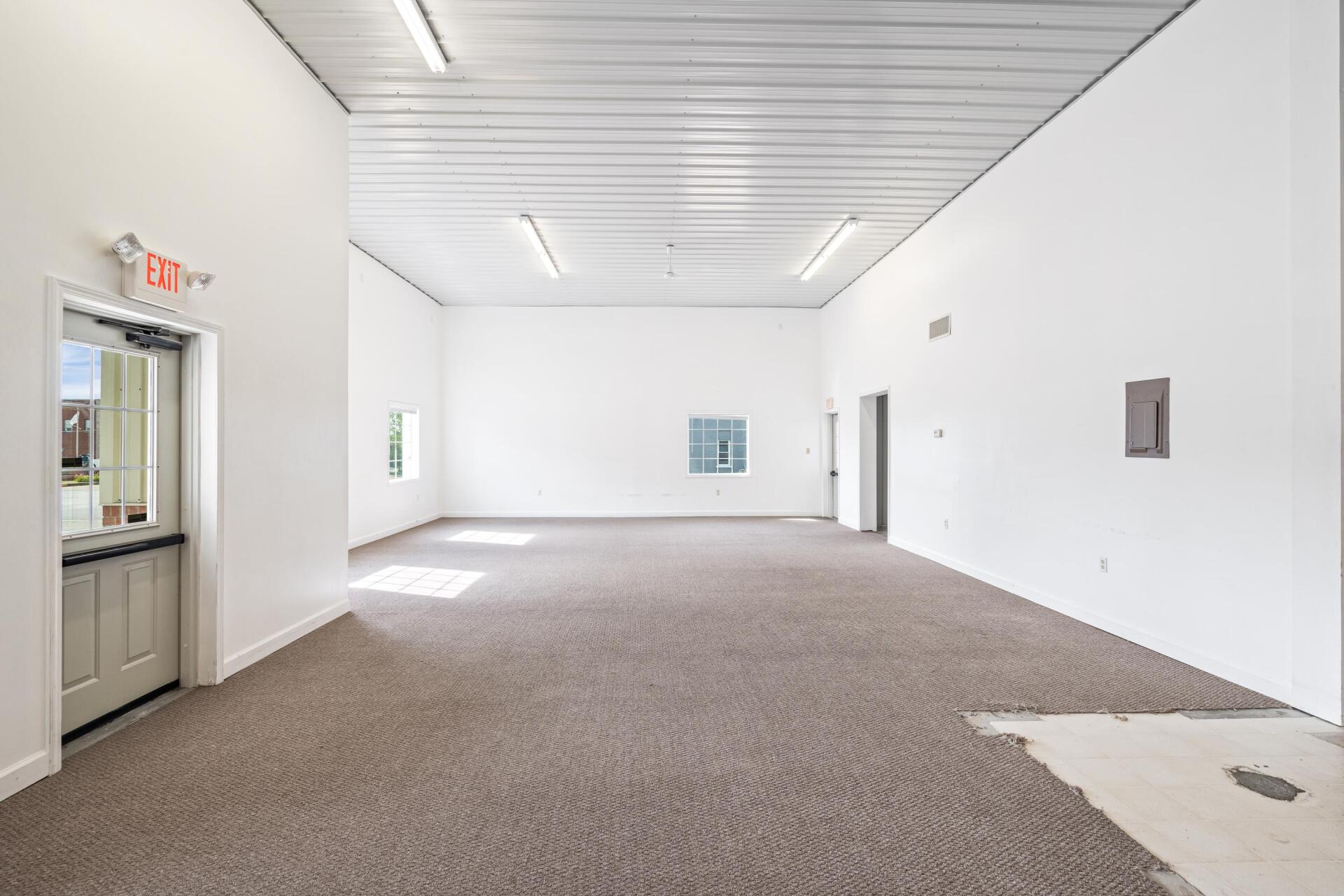 A large empty room with a carpeted floor and white walls.