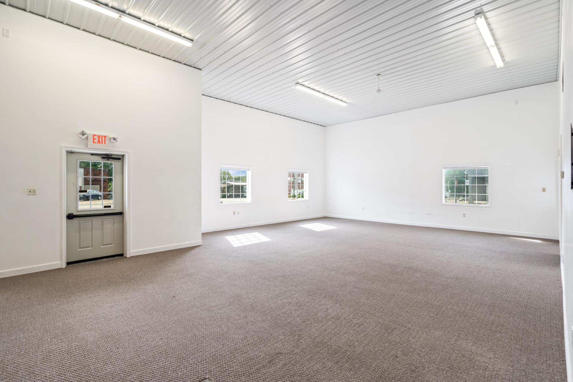 A large empty room with a carpeted floor and white walls.