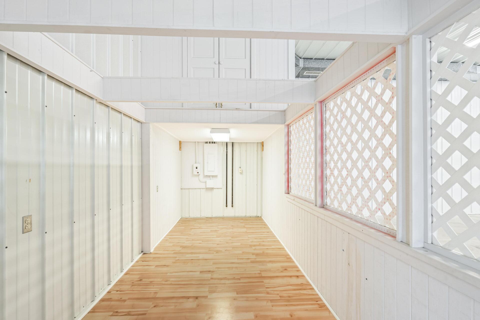 An empty hallway with white walls and wooden floors