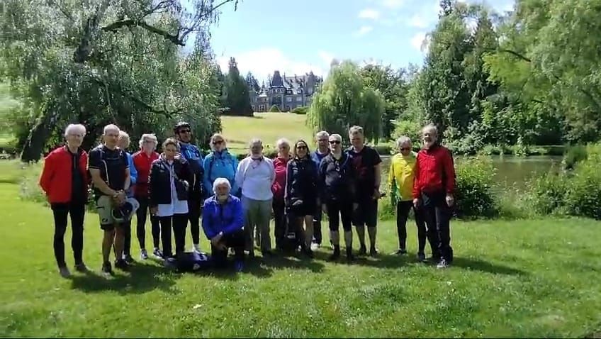 Eine Gruppe von Menschen posiert in einem Park für ein Foto.