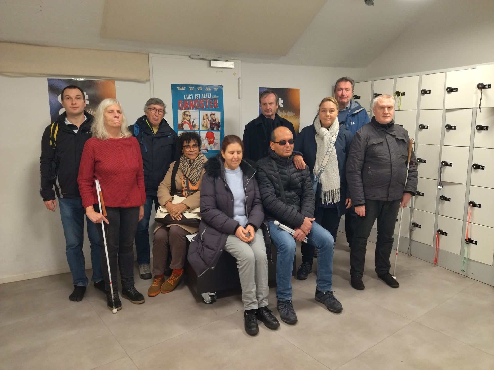 Eine Gruppe von Menschen posiert in einem Raum mit Schließfächern für ein Foto.