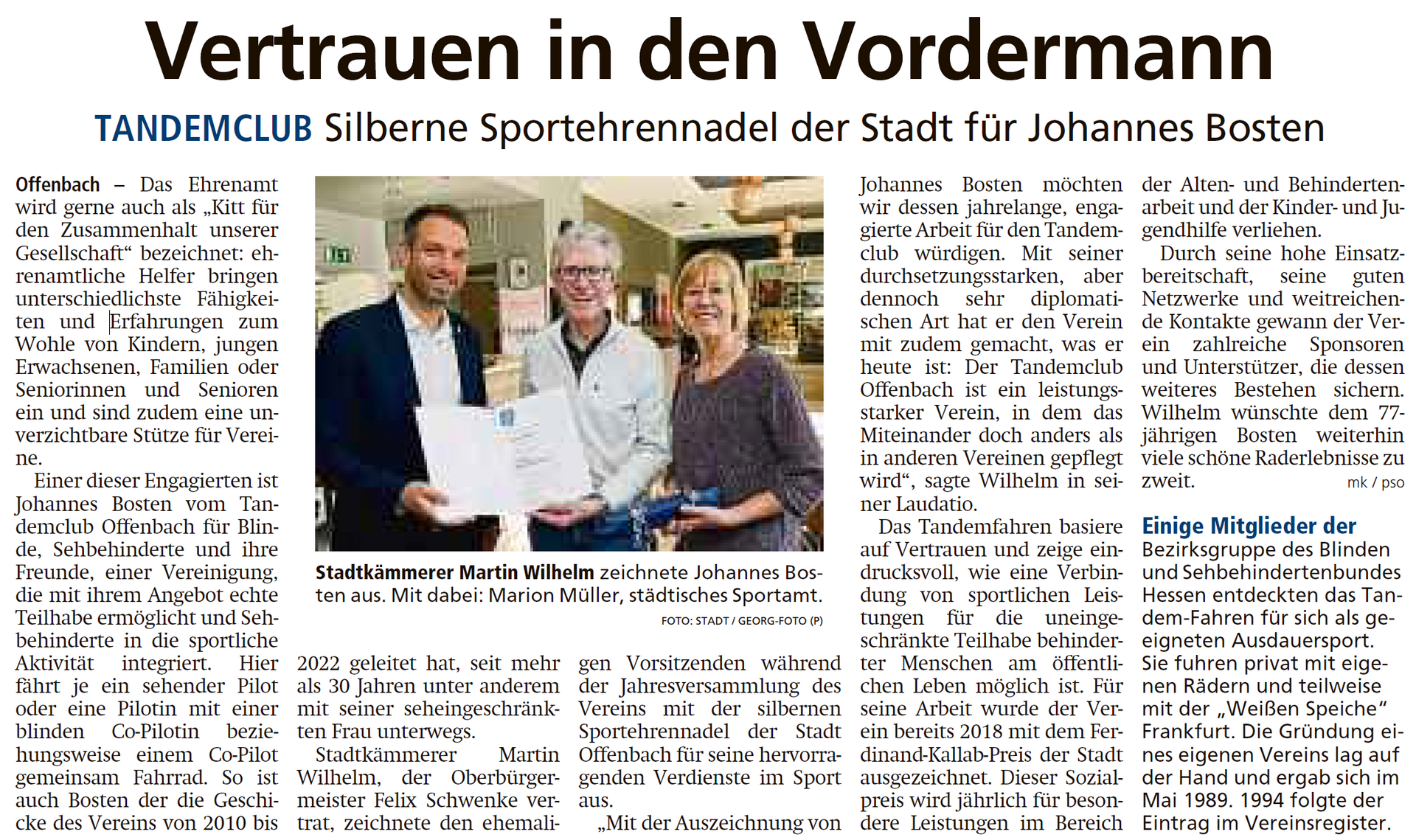 Ein Zeitungsartikel über eine Gruppe von Menschen, die nebeneinander stehen.
