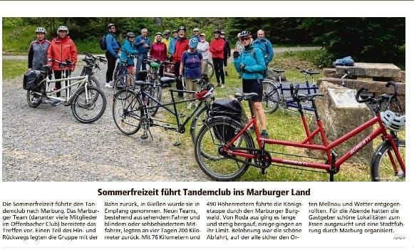 In einem Zeitungsartikel steht eine Gruppe von Menschen neben Fahrrädern.