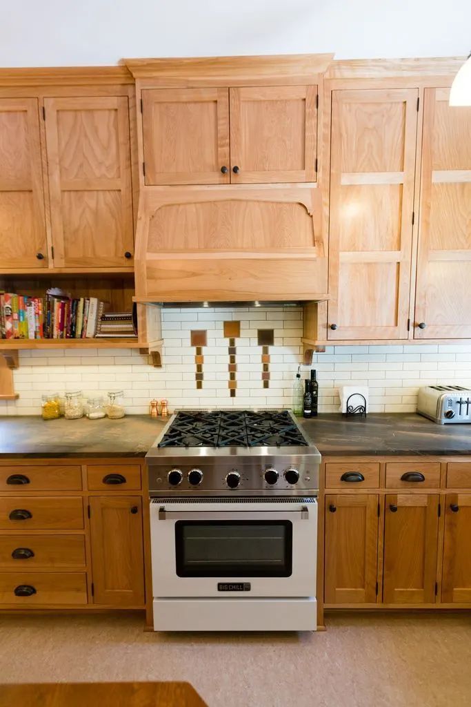 Kitchen with wooden cabinets, stainless steel stove, and tiled backsplash