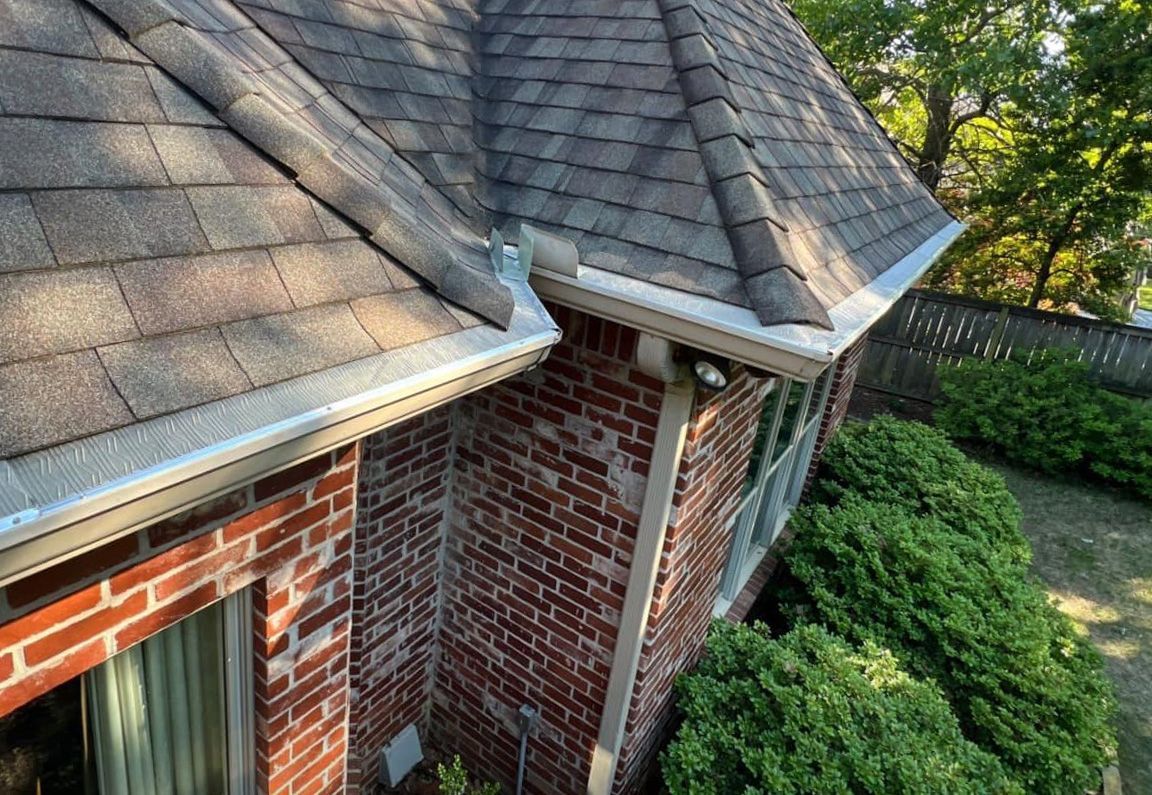 A brick house with a gutter on the side of it
