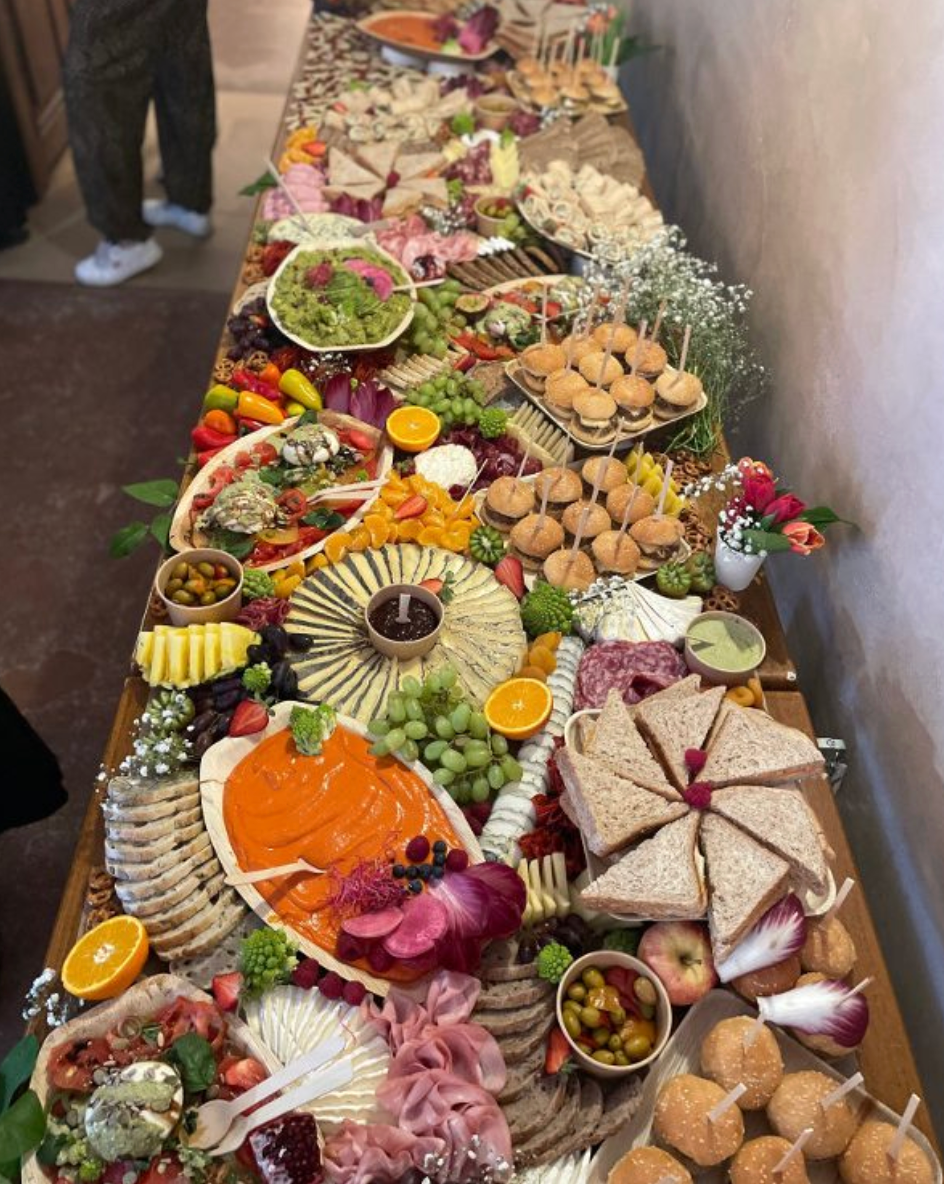 Grazing Table généreuse composée de charcuteries, fromages, fruits, légumes et mini-sandwichs