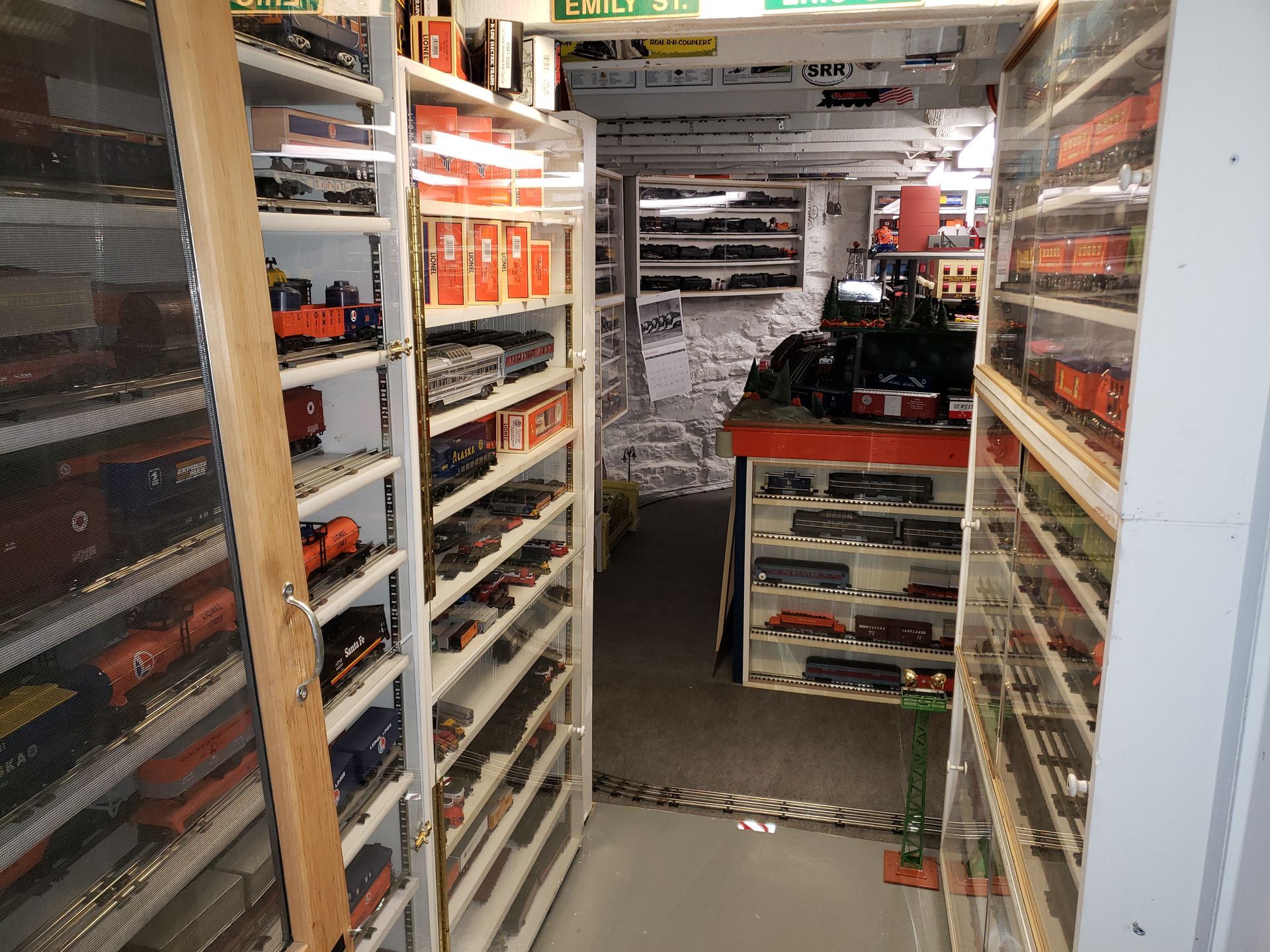 A narrow grocery aisle with shelves of packaged goods and a small display table in the center.