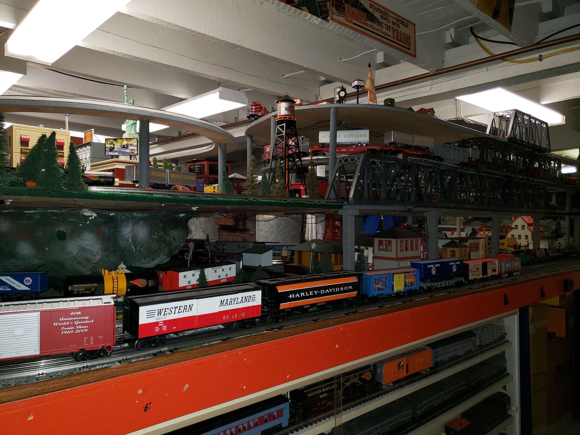 Model train layout with multiple trains and tracks in a large indoor display