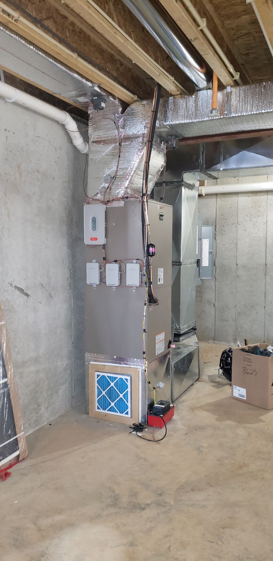 Basement HVAC room with ductwork, furnace, and unfinished concrete walls and ceiling