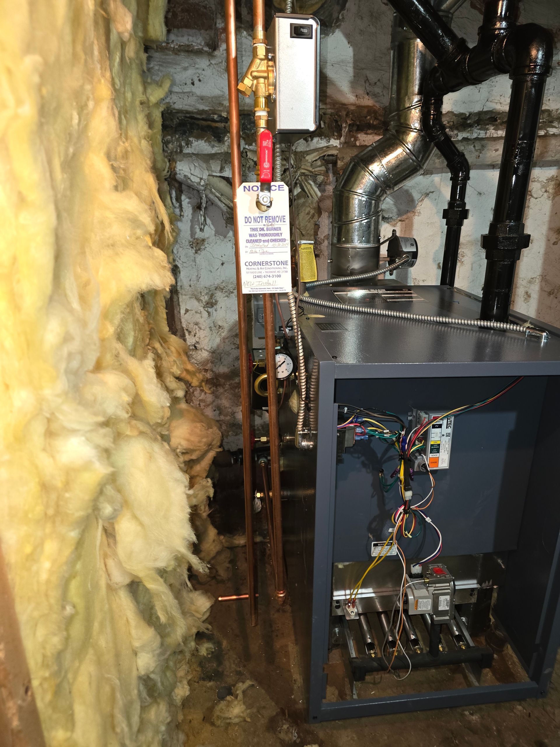Furnace area with exposed yellow insulation, metal ductwork, and an open HVAC unit cabinet.
